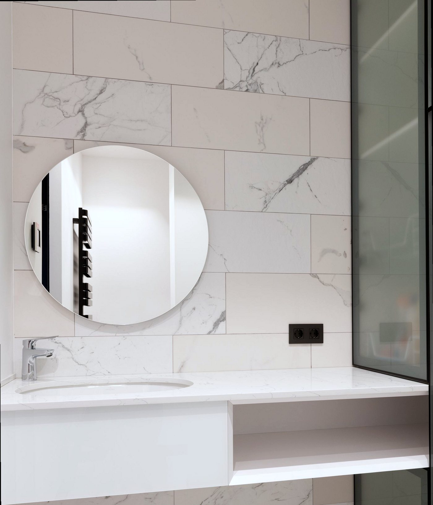 Large marble-effect wall tiles around a basin